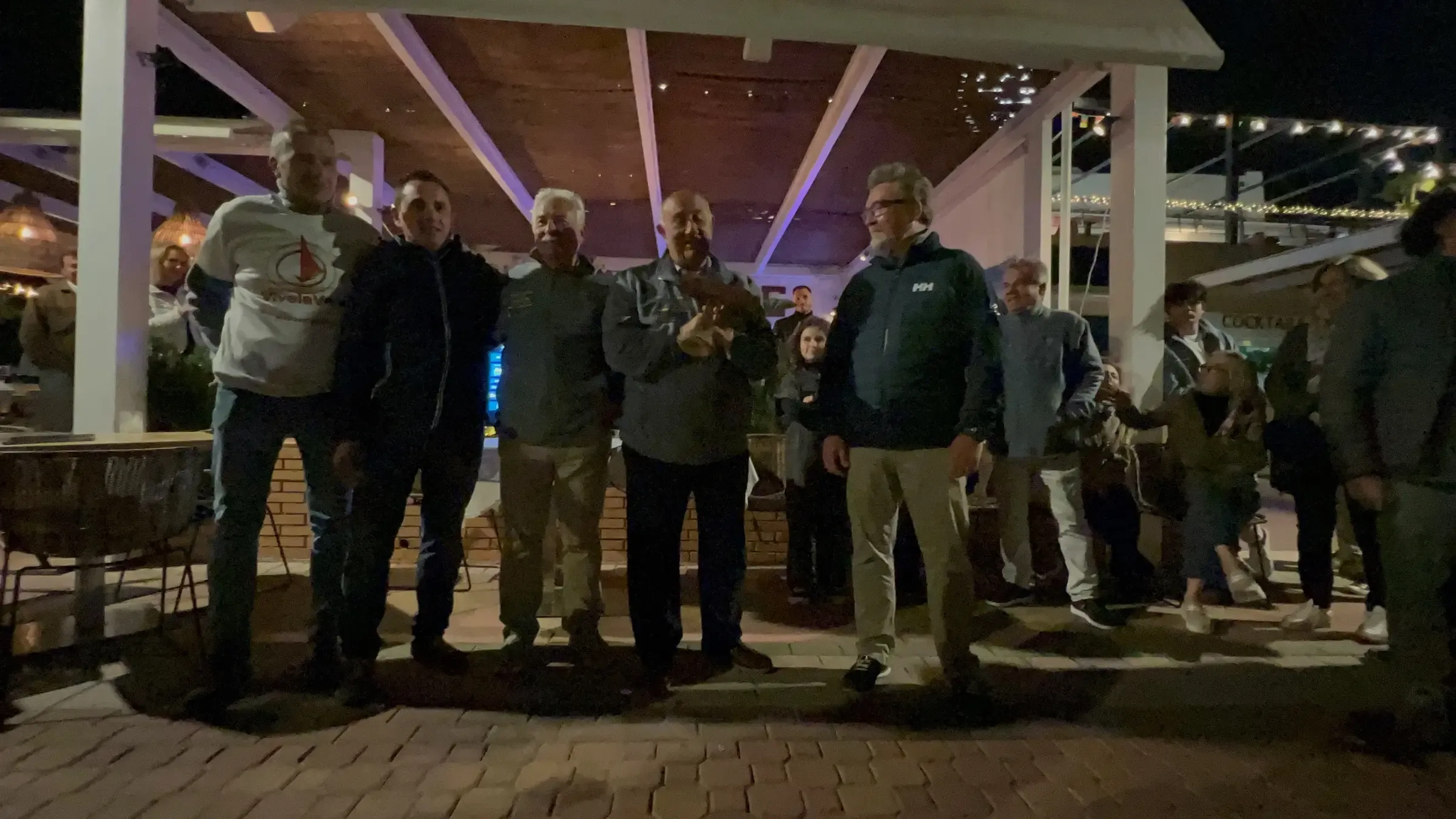 Participantes de la regata reunidos de noche en la terraza del club náutico