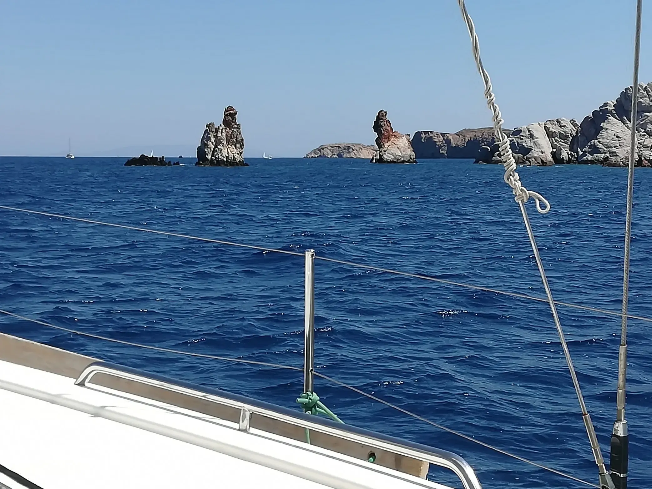 Formaciones rocosas que emergen del mar azul intenso, vistas desde la cubierta del velero