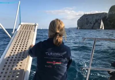 Una navegante con una sudadera de Turkana mira el mar desde la proa de un velero