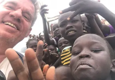 Un voluntario se fotografía rodeado de niños sonrientes